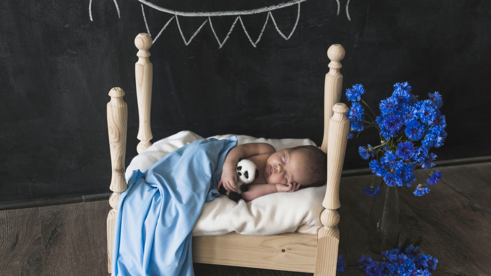 Маленький ребенок спит в деревянной кровати 