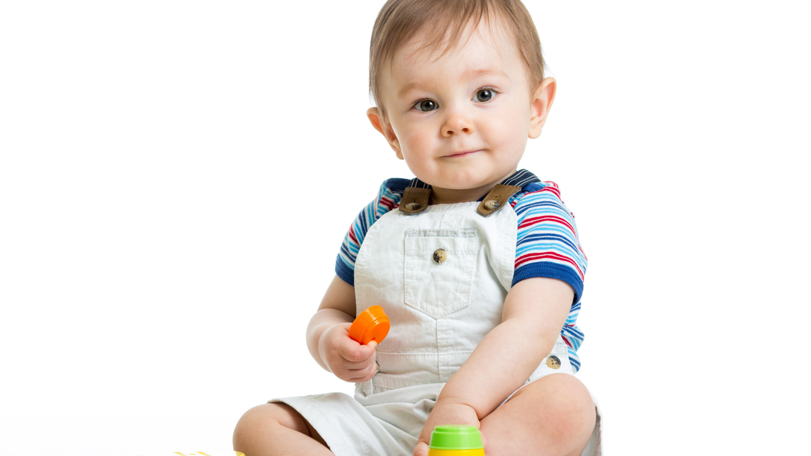 Маленький мальчик играет с пирамидкой на белом фоне