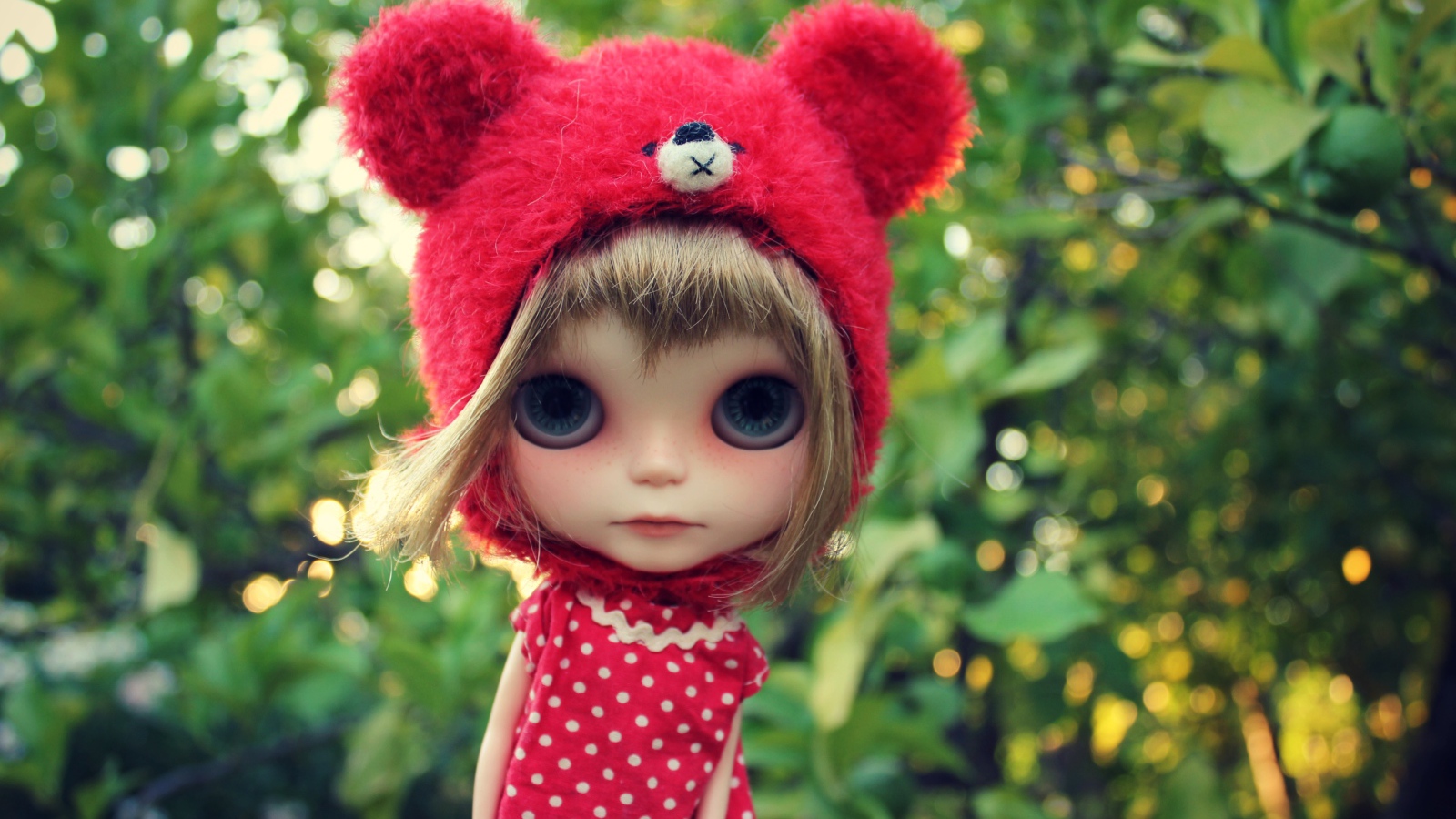 Маленькая кукла с большими глазами в красной шапке