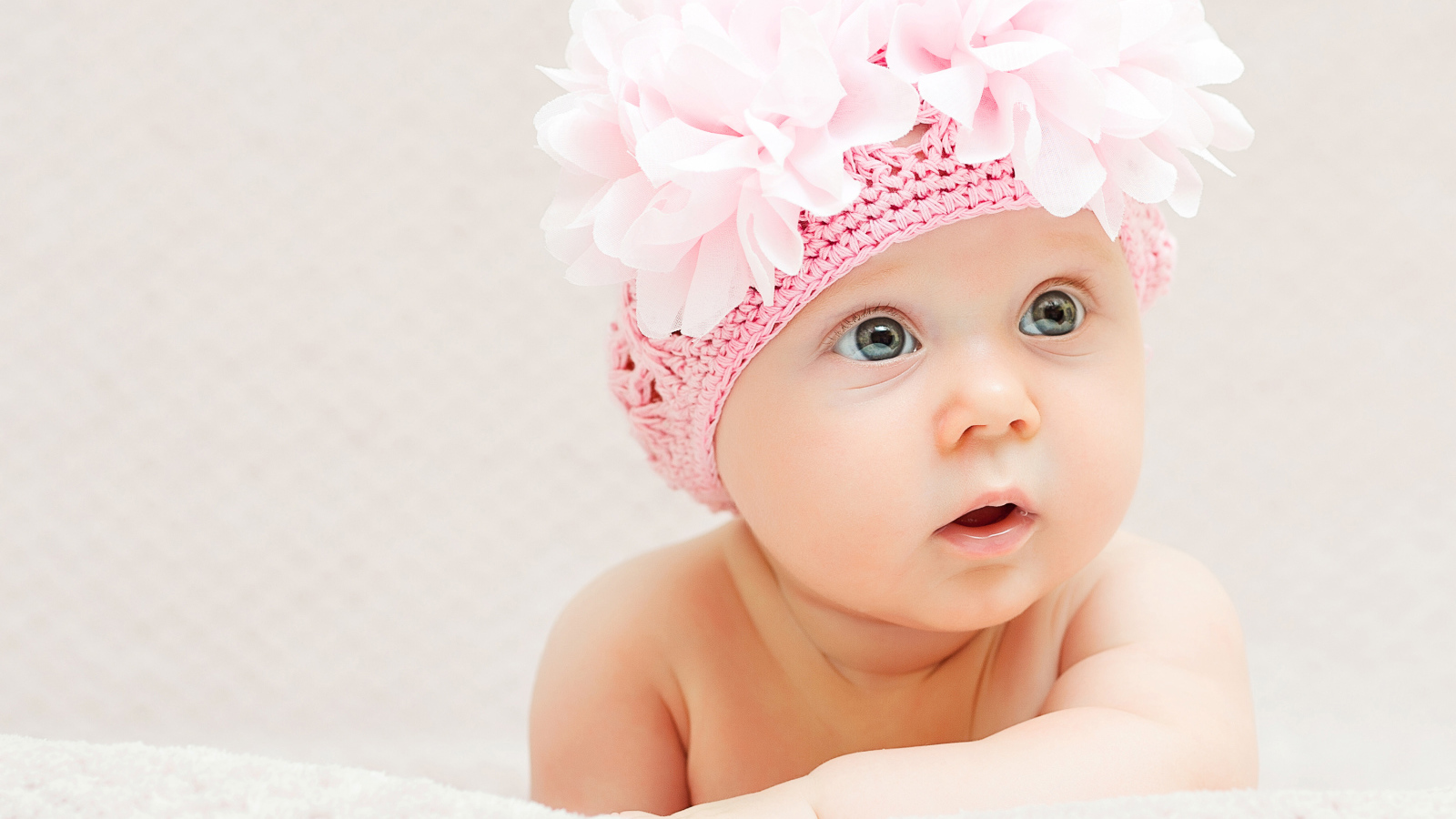 Маленькая девочка в вязаной шапке с цветами