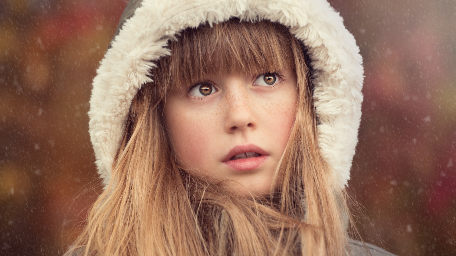 Маленькая девочка с веснушками на лице в капюшоне 