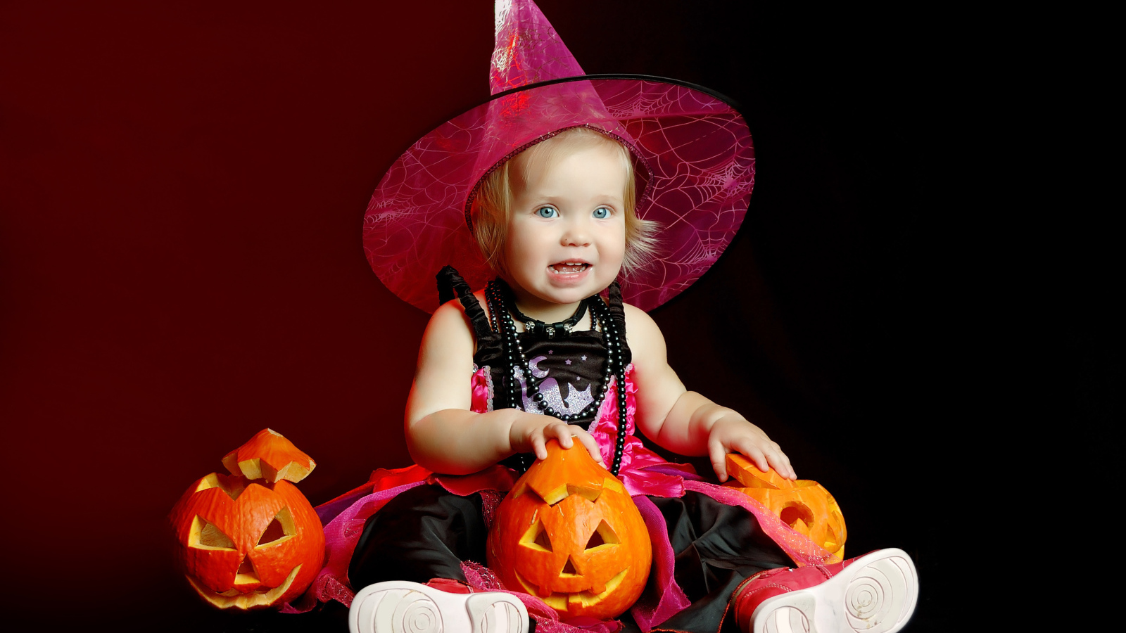 Маленькая девочка с тыквой в костюме на праздник Хэллоуин 