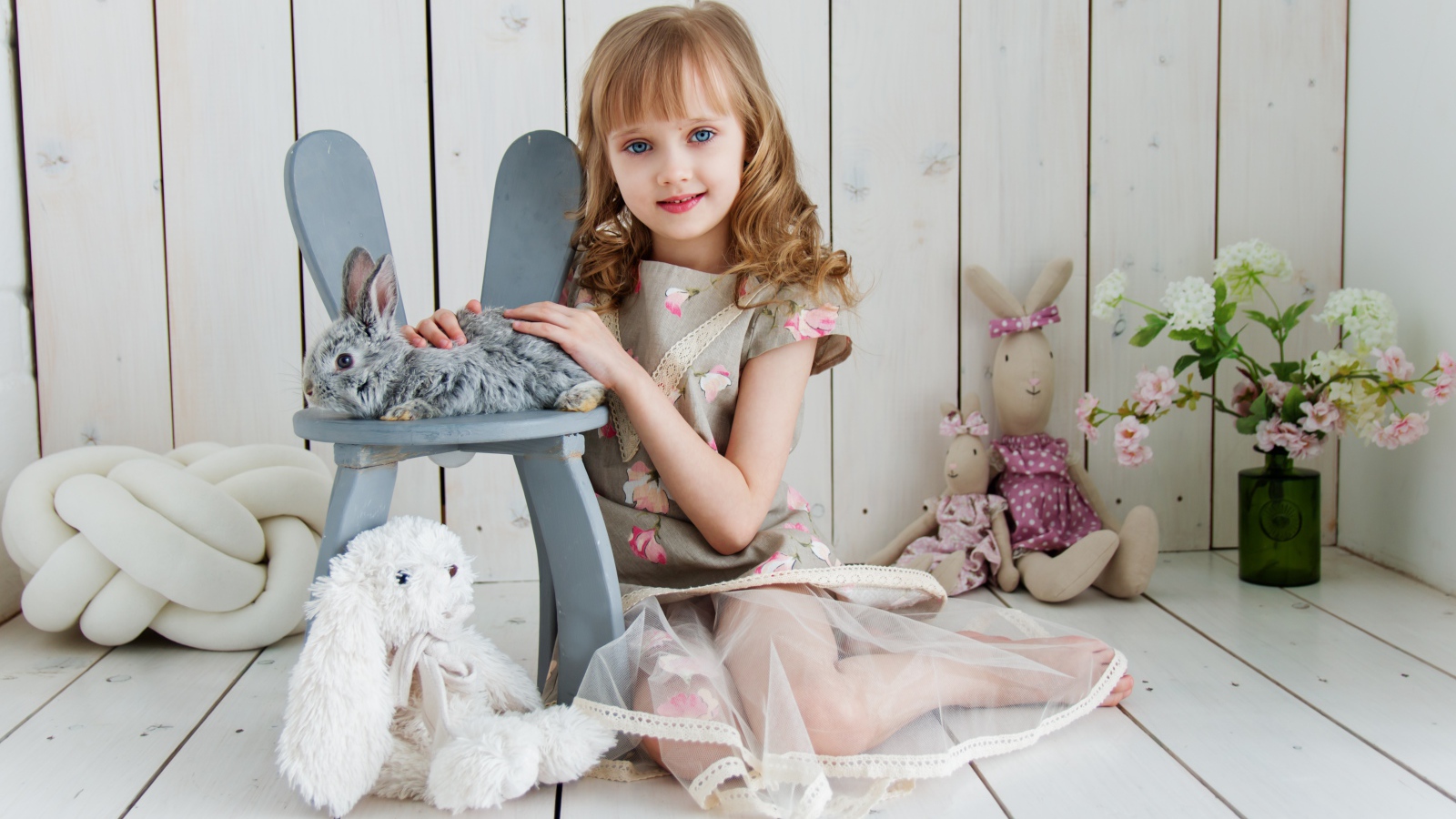 Маленькая девочка с игрушками в комнате сидит на полу