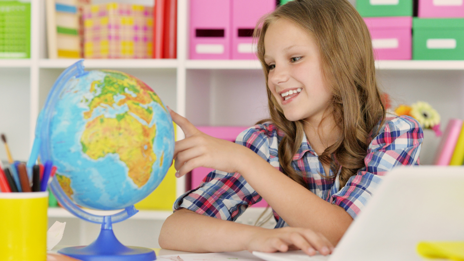 Улыбающаяся девочка школьница с глобусом