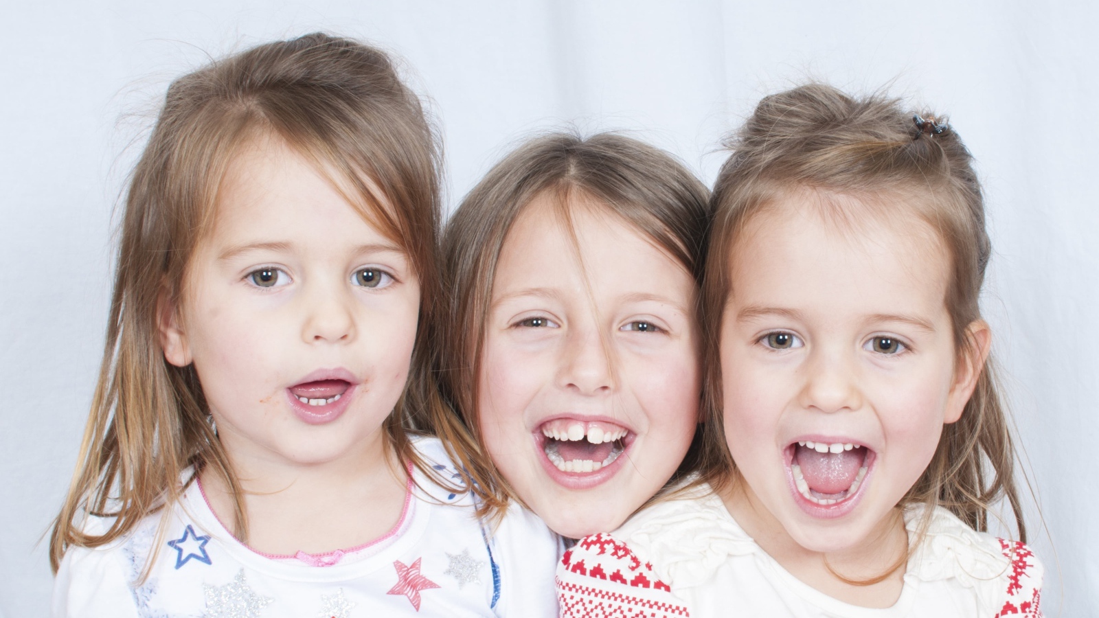 Три маленькие улыбающиеся девочки сестры 