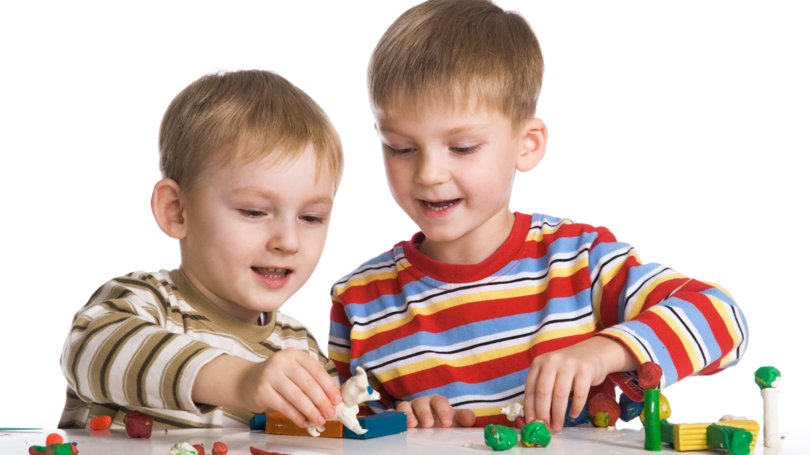 Два мальчика играют в игрушки на белом фоне
