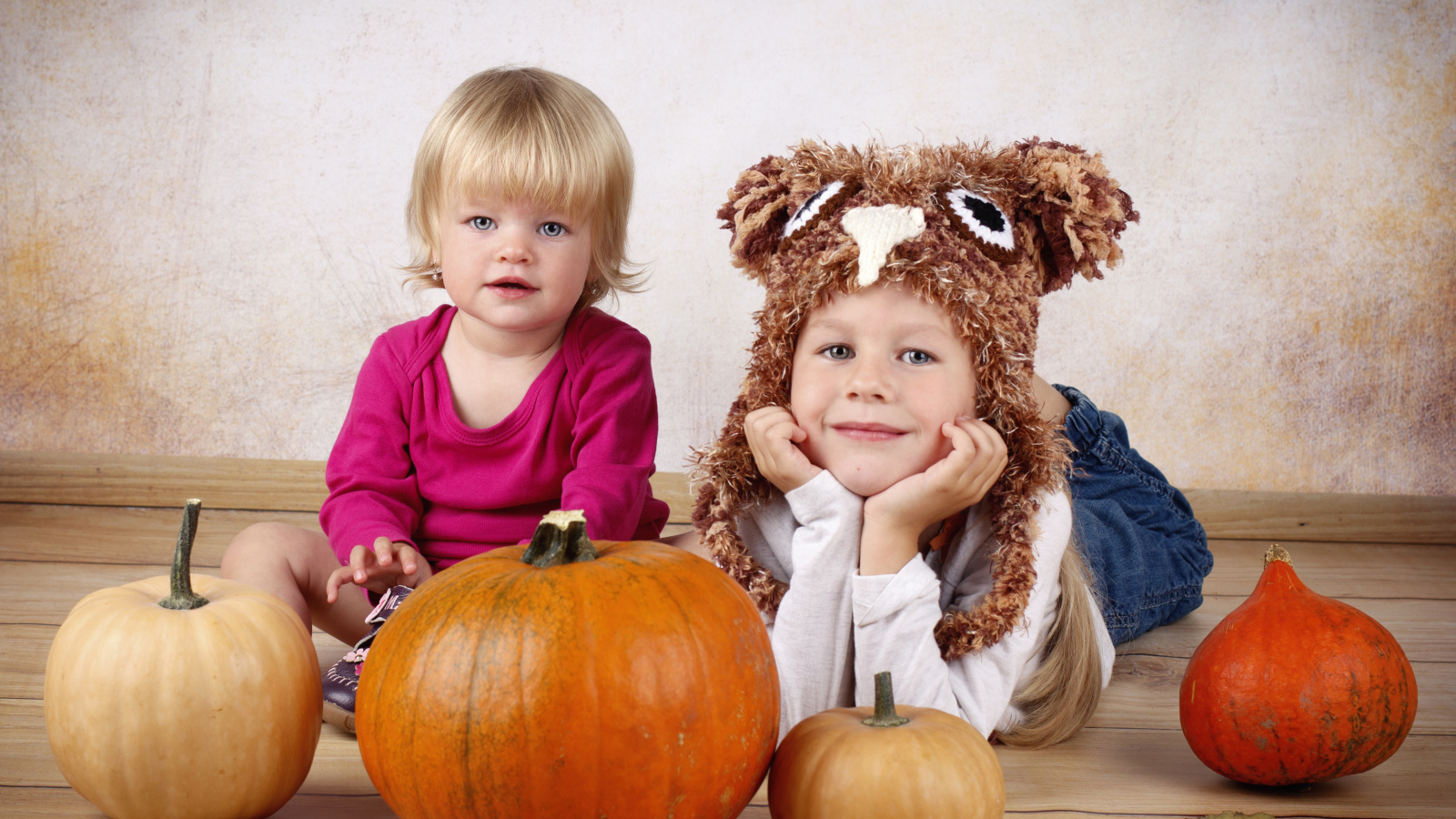 Два маленьких ребенка с тыквами в комнате