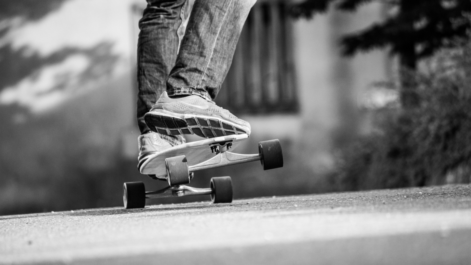 Парень катается на скейтборде по асфальту