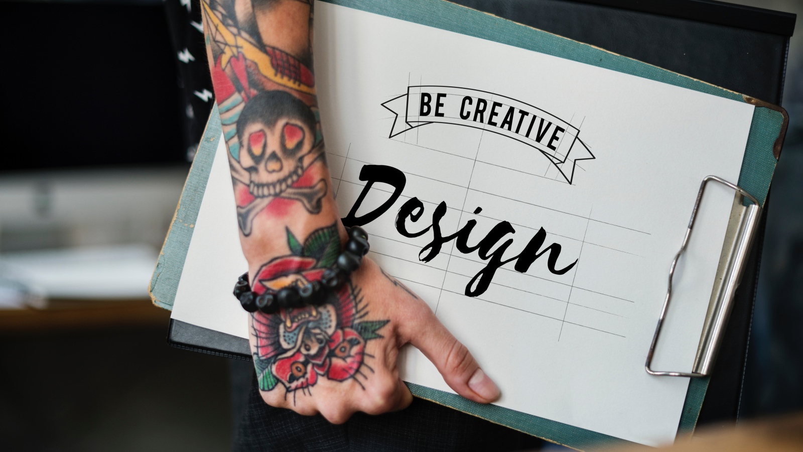 Мужчина с татуировкой на руке держит папку