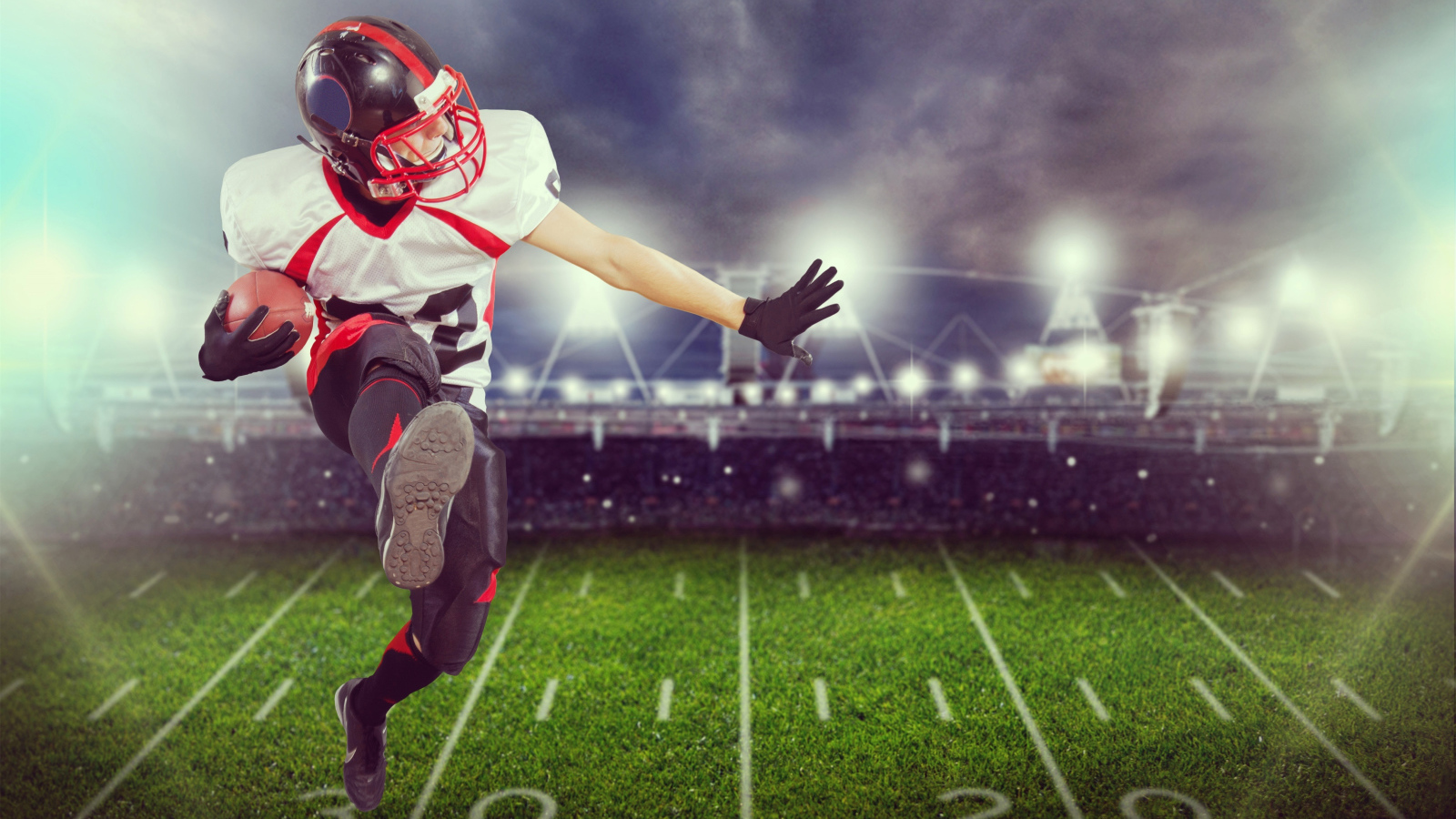 Игрок в американский футбол с мячом на поле