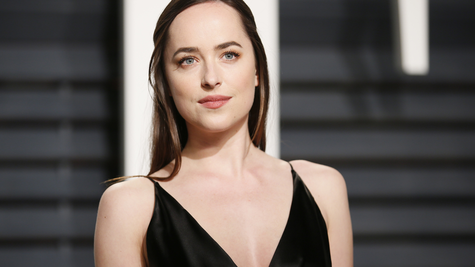 Красивая голубоглазая девушка актриса Дакота Джонсон в черном платье