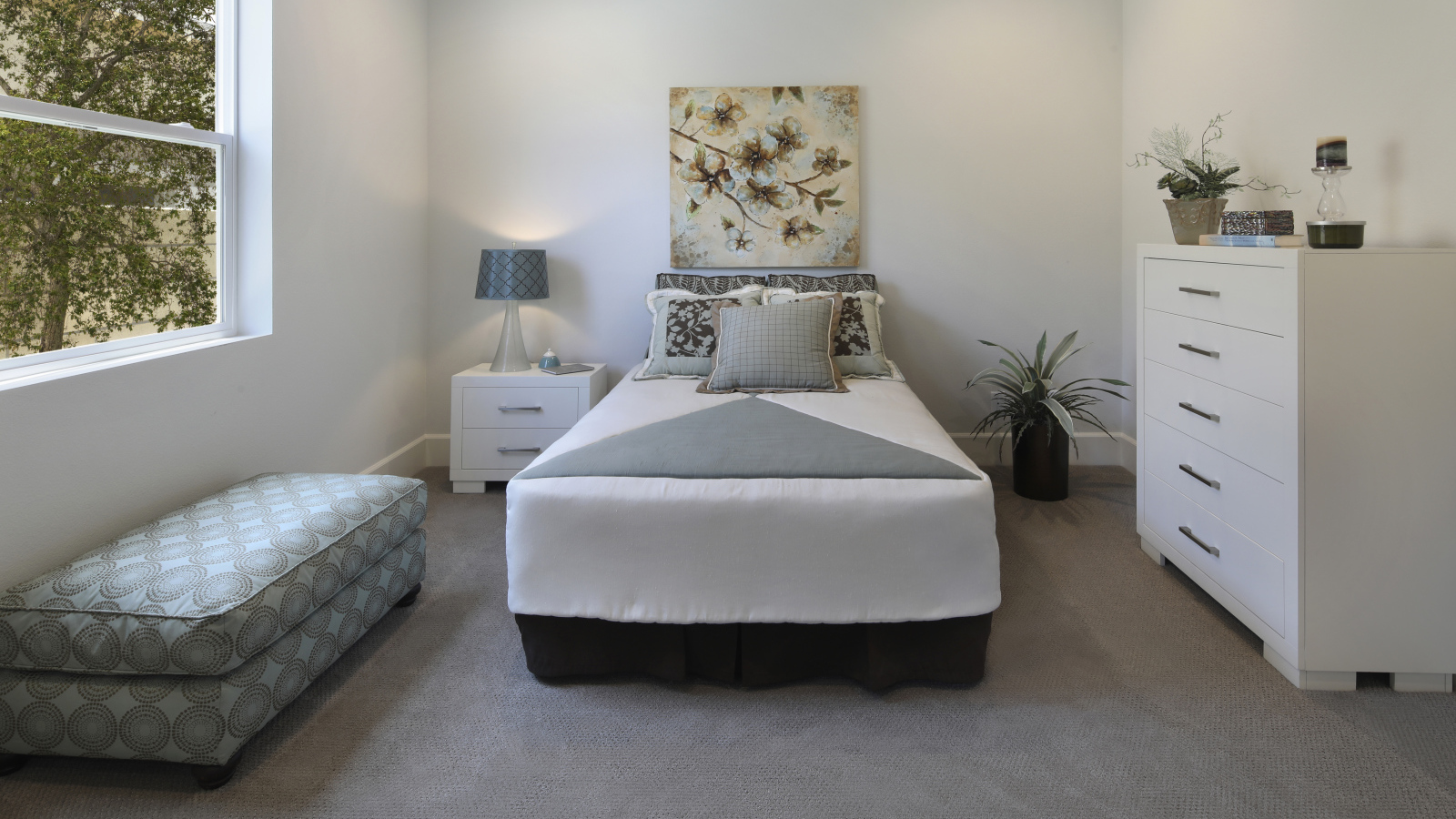 Спальная комната с кроватью и мягкой лежанкой у окна 