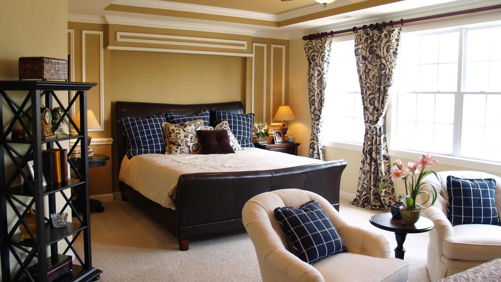 Спальня с большой кожаной кроватью и креслами 