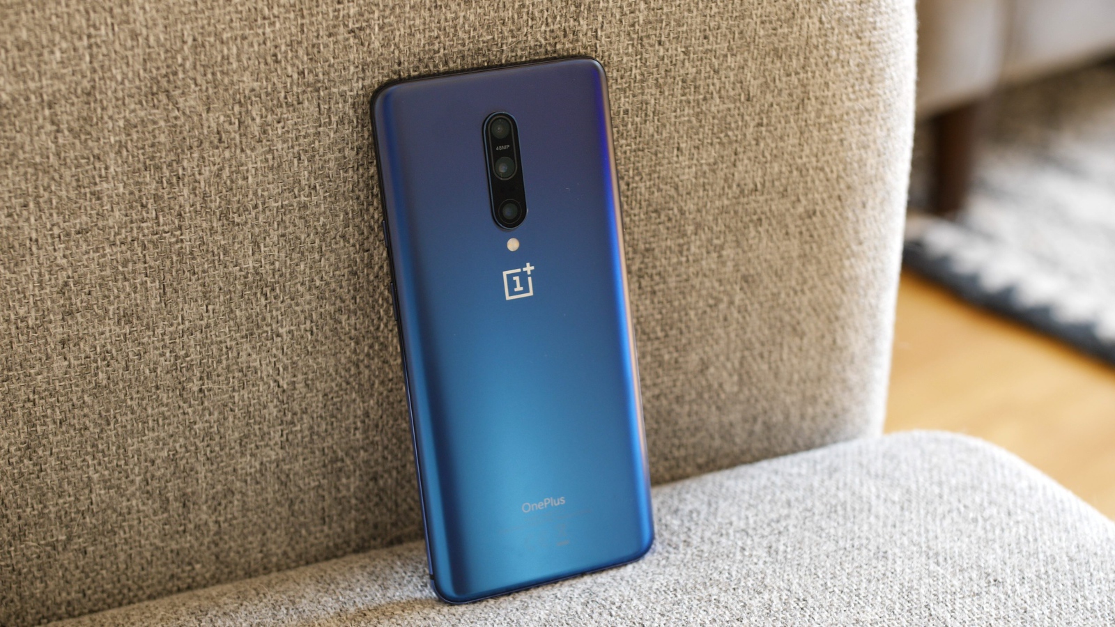 Синий смартфон ONEPLUS 7 на диване