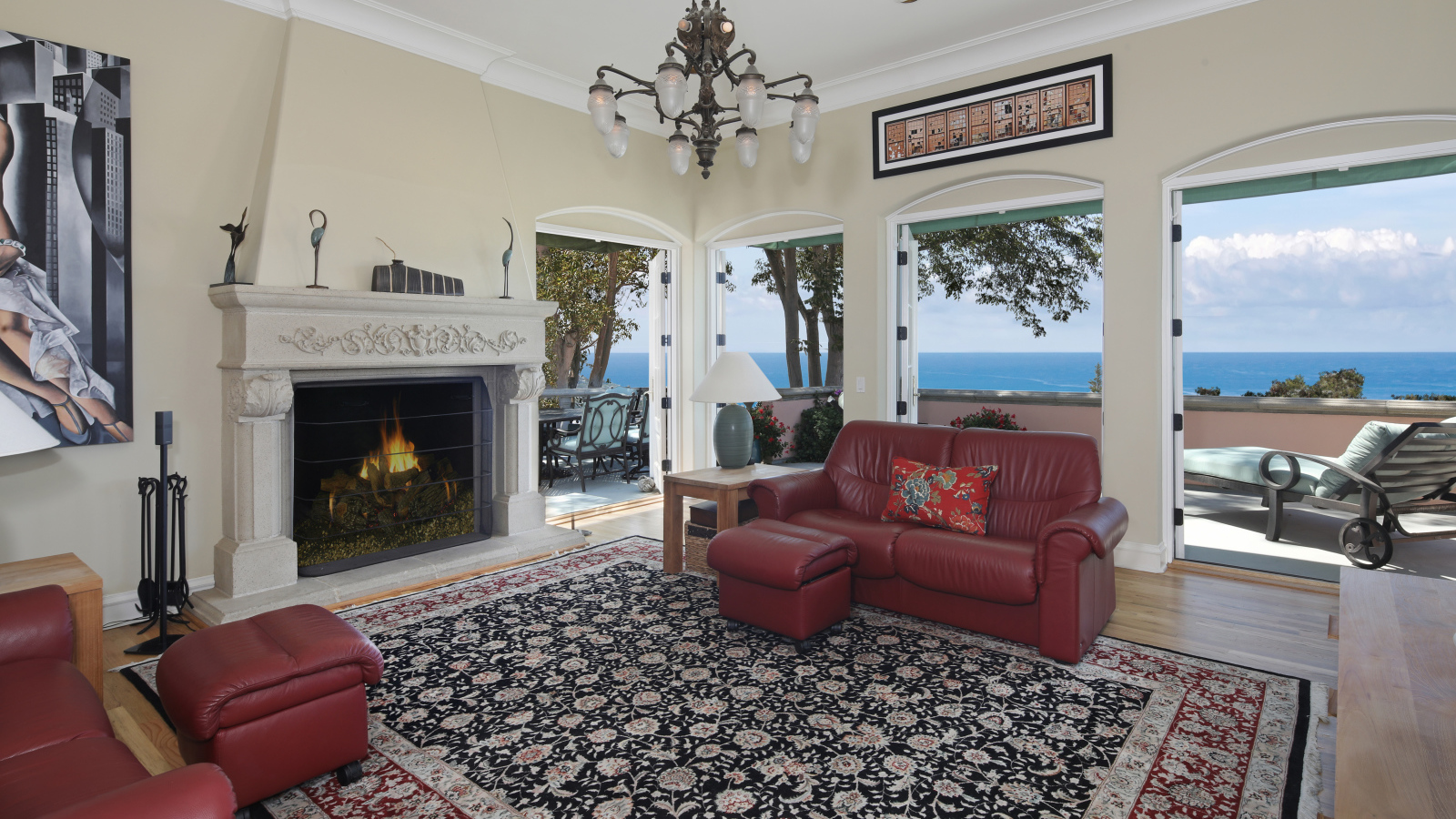 Гостиная с кожаным диваном, большими окнами и камином 