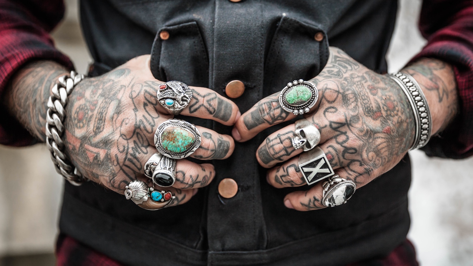 Татуировки на руках мужчины с перстнями