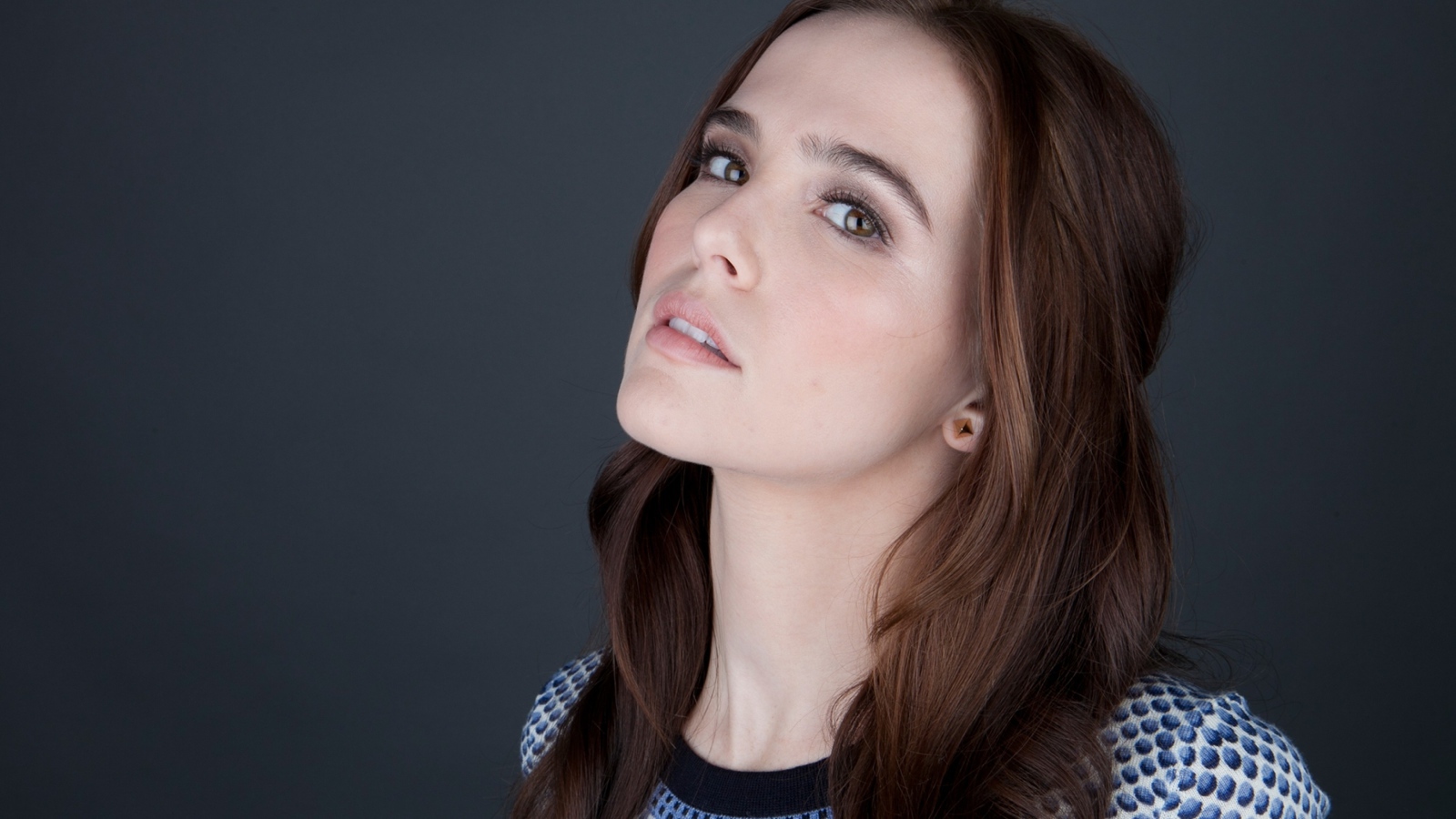Нежная кареглазая шатенка, актриса Зои Дойч на сером фоне