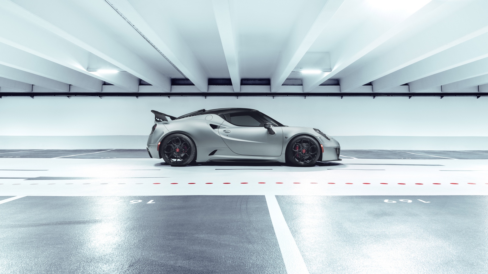 Серый автомобиль Pogea Racing Nemesis 2020 года на парковке 