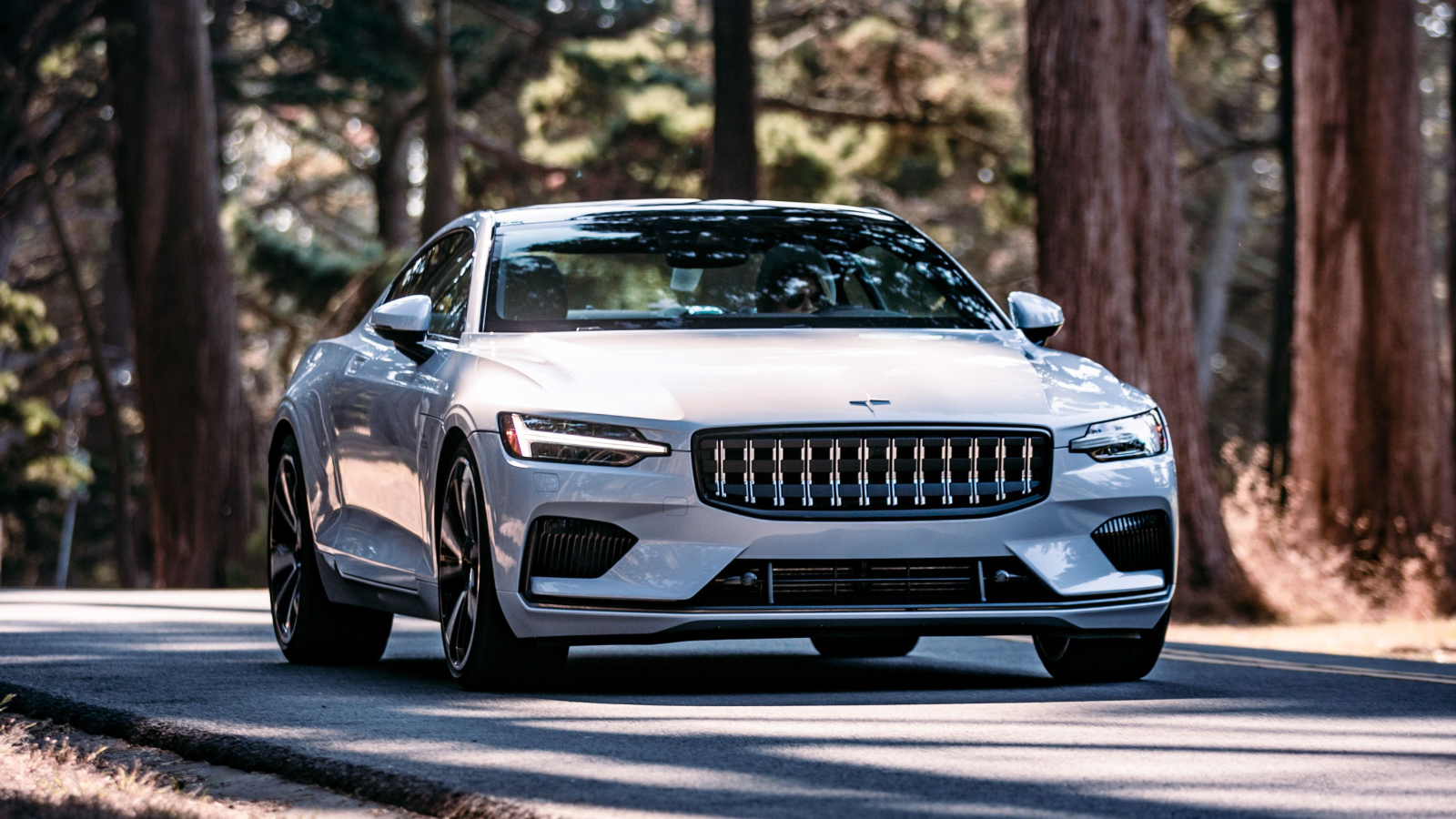 Белый автомобиль Polestar 1 2021 года едет по дороге