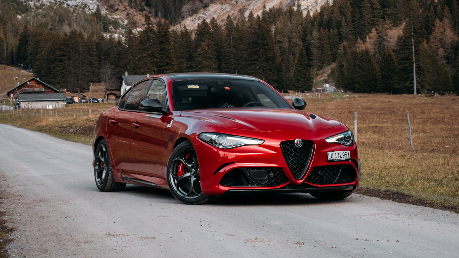 Красный автомобиль Alfa Romeo Giulia Quadrifoglio 2021  года на фоне гор