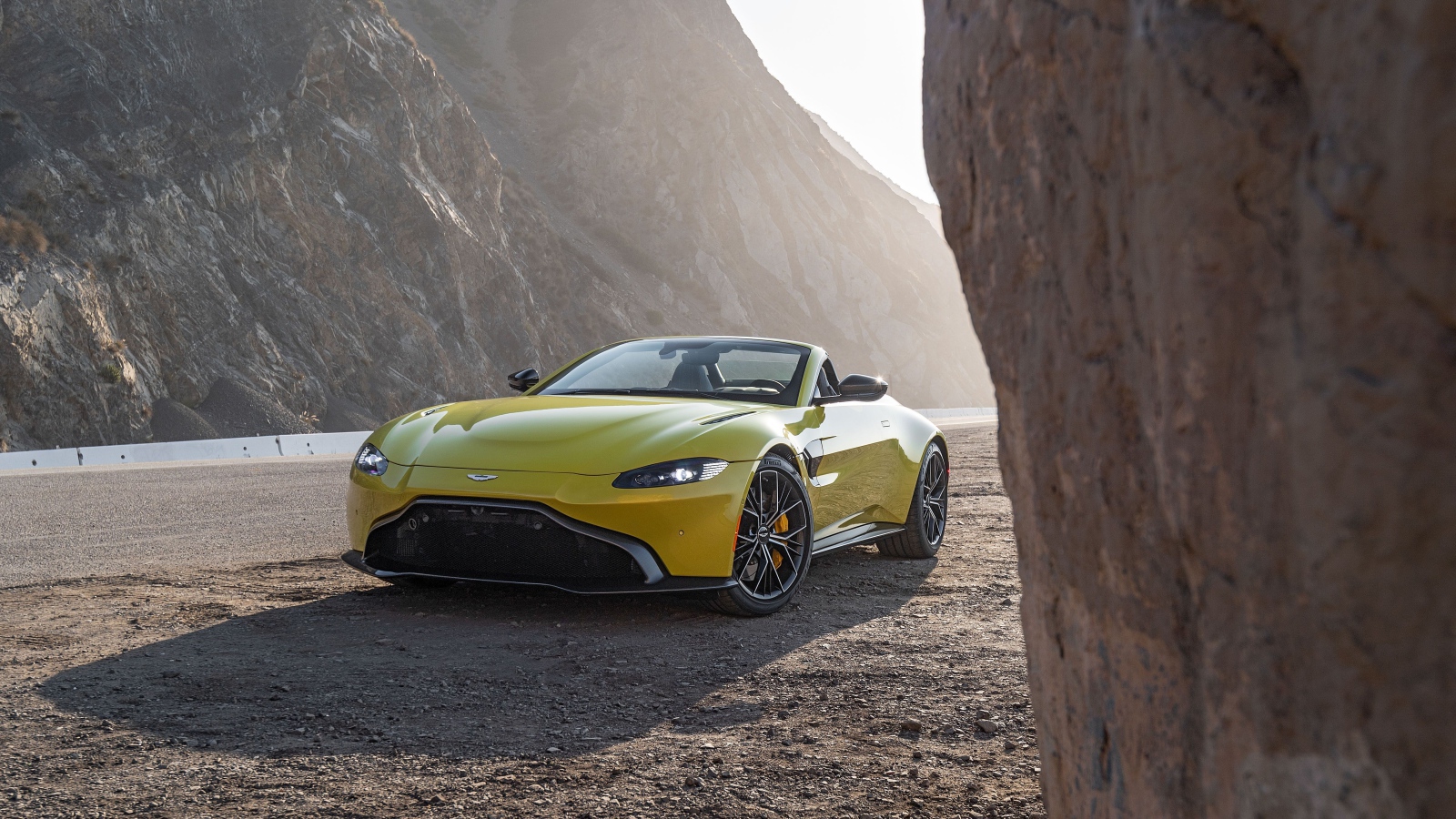 Желтый автомобиль  Aston Martin Vantage Roadster, 2021 года в горах 