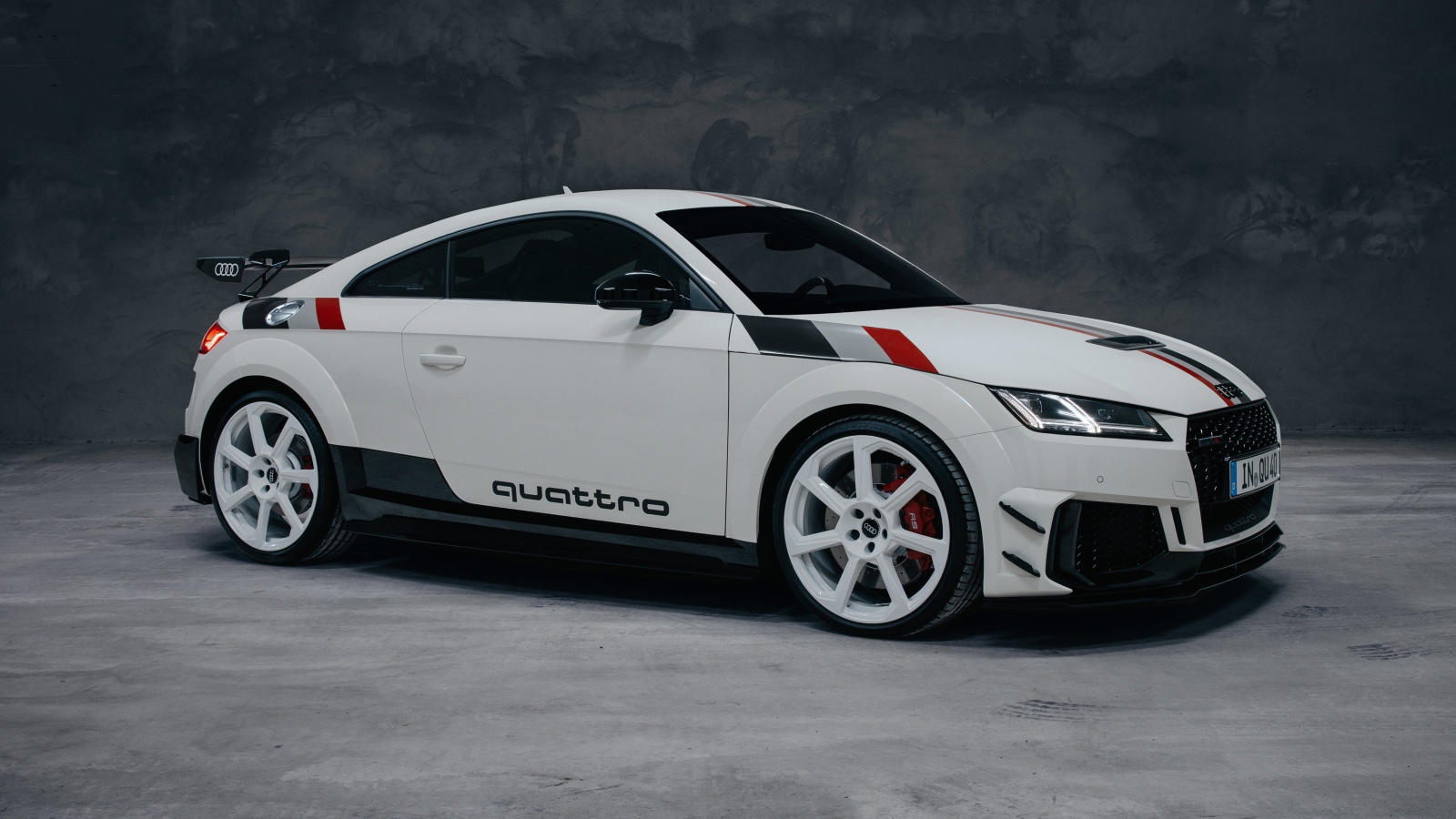 Белый автомобиль Audi TT RS Coupé 40 Jahre Quattro 2020 года на сером фоне