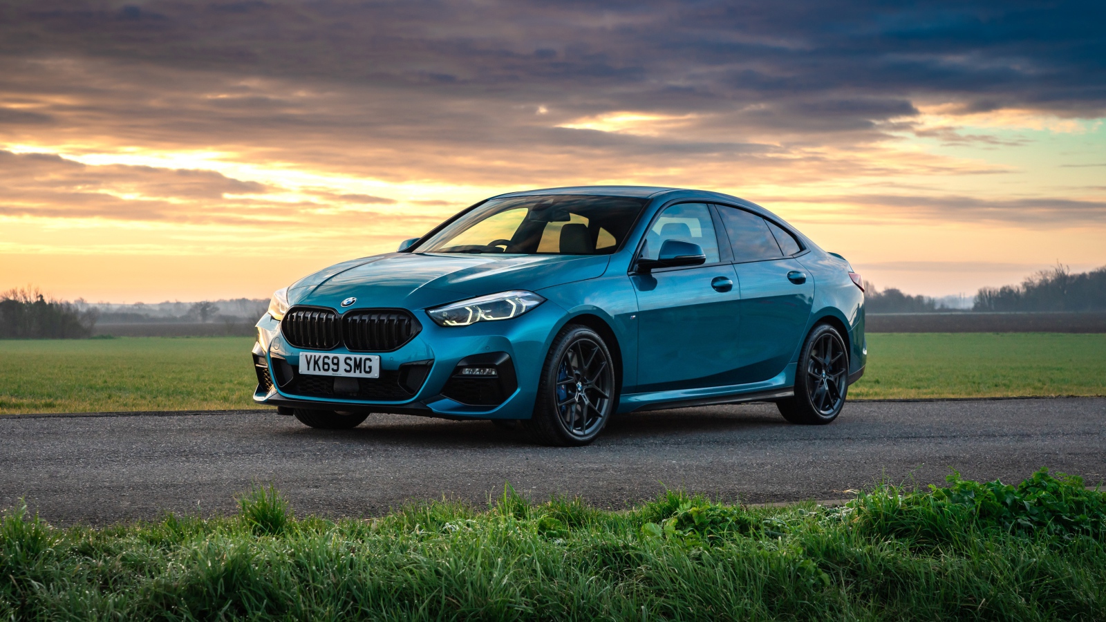 Синий автомобиль BMW 218i Gran Coupe M Sport 2020 года на фоне заката