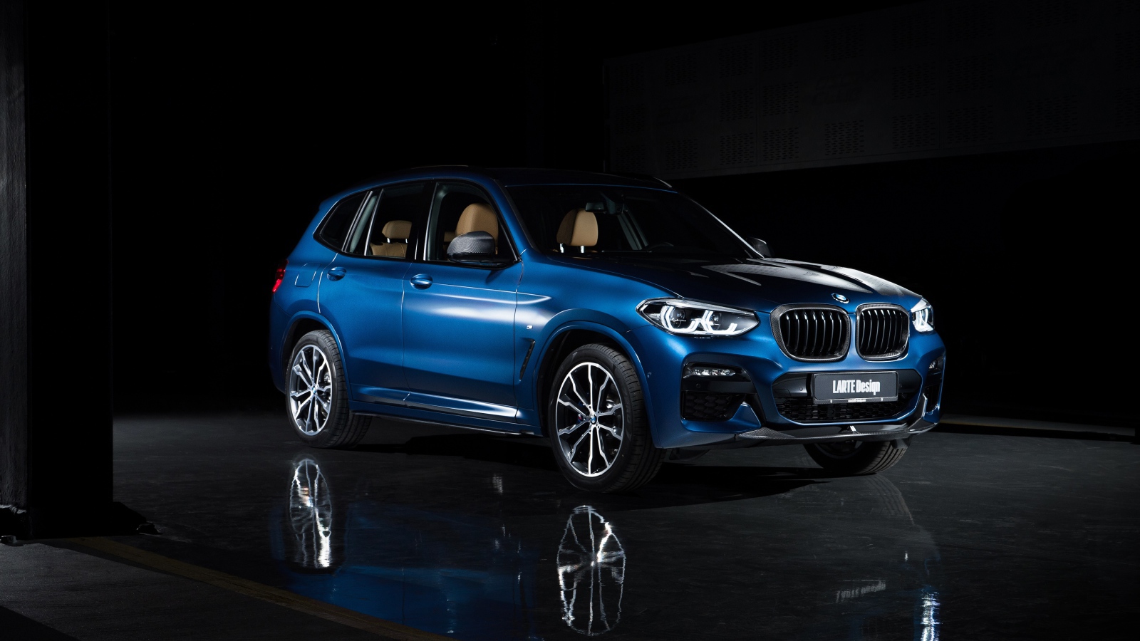 Синий автомобиль Larte Design BMW X3 XDrive30d 2020 года на черном фоне