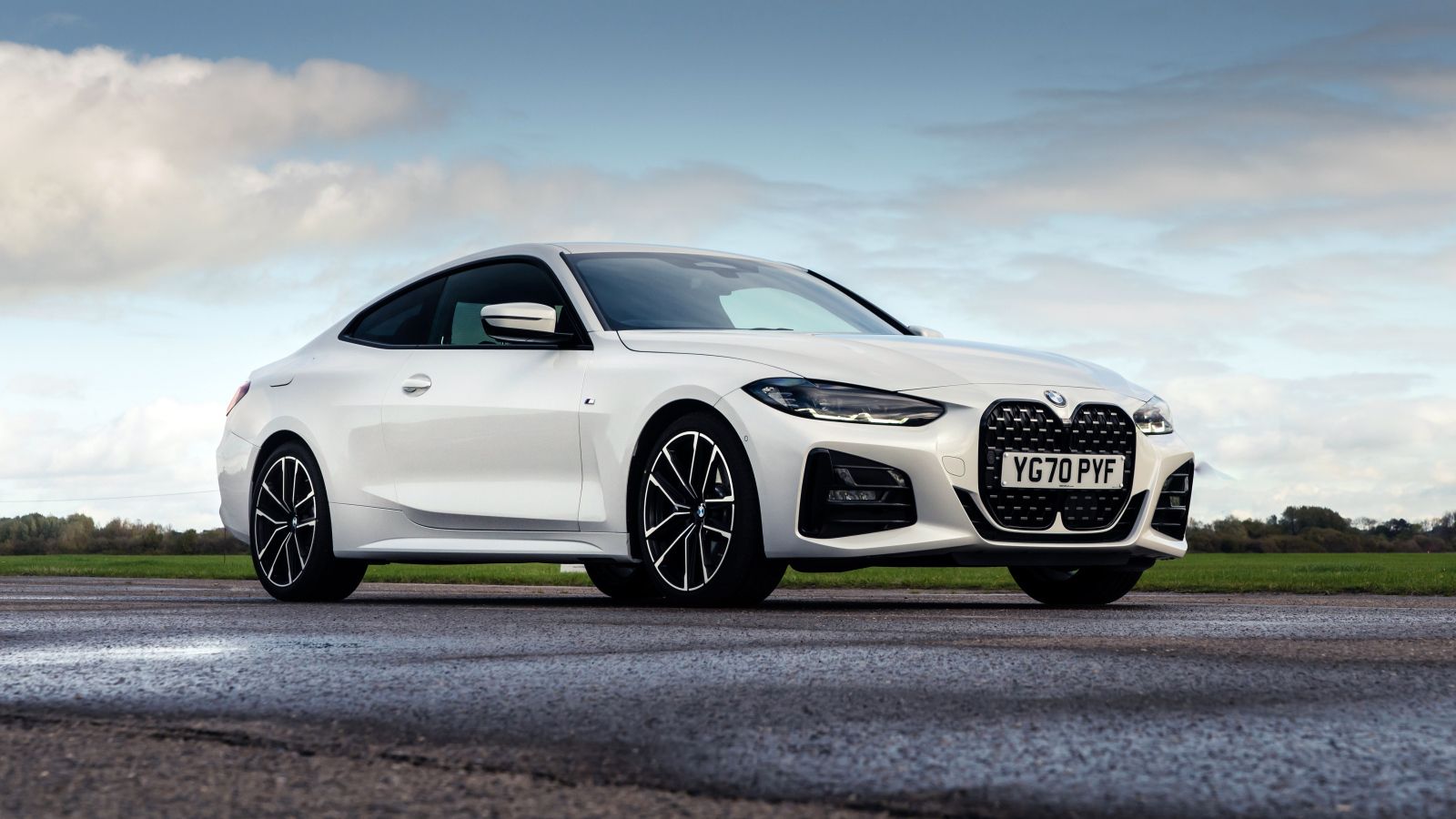 Белый автомобиль BMW 420i Coupé M Sport 2020 года на фоне неба