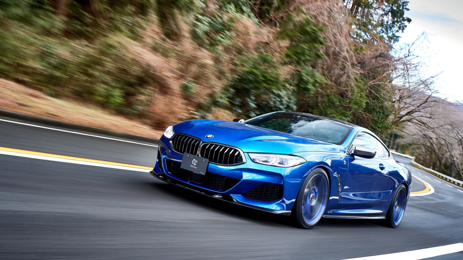 Синий автомобиль  BMW M850i XDrive Coupe 2020 года на дороге