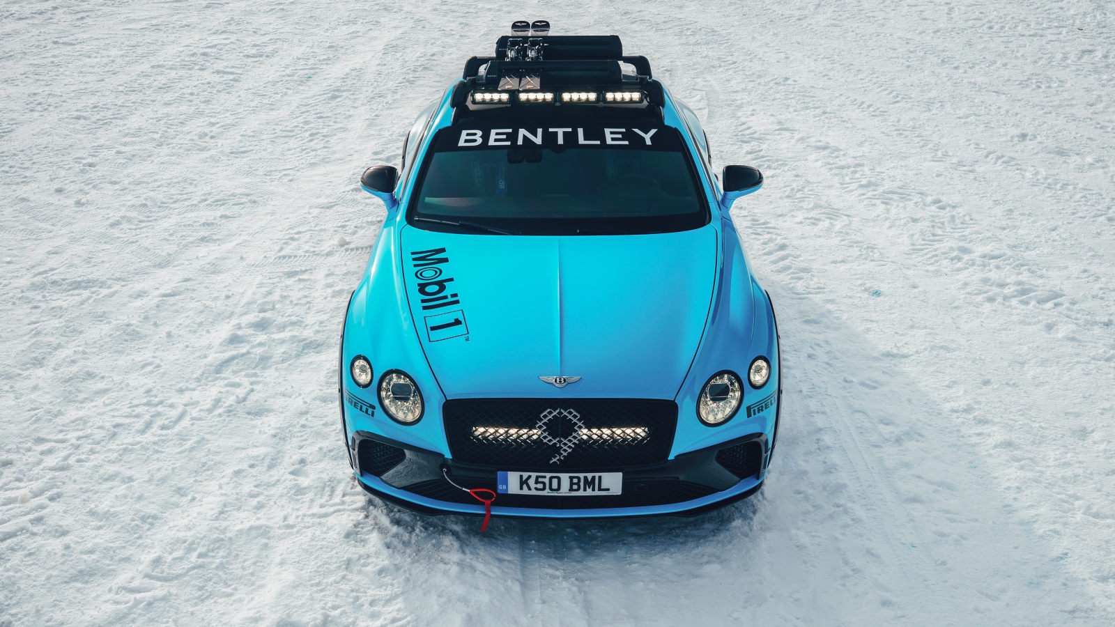 Голубой автомобиль Bentley Continental GT Ice Race 2020 года стоит на заснеженной дороге 