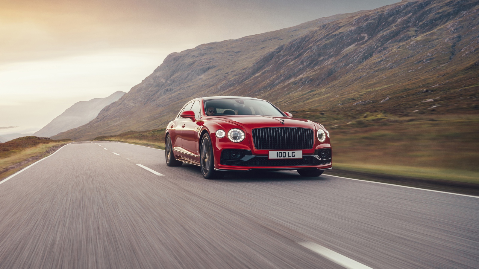 Красный автомобиль Bentley Flying Spur V8 2020 года на дороге  