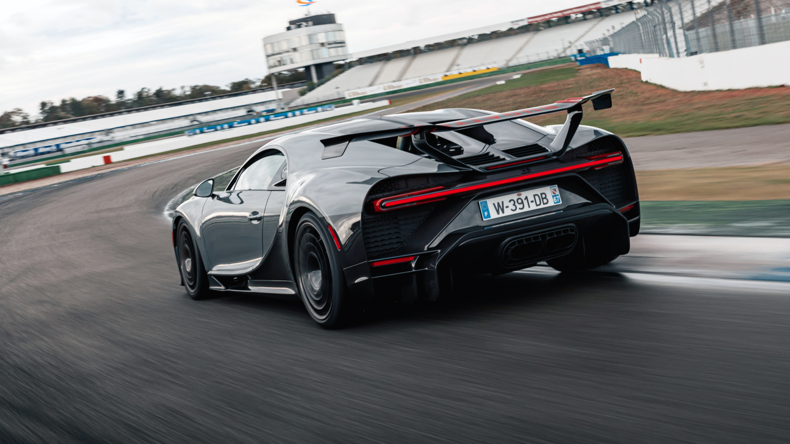 Черный быстрый автомобиль Bugatti Chiron Pur Sport 2020 года на стадионе