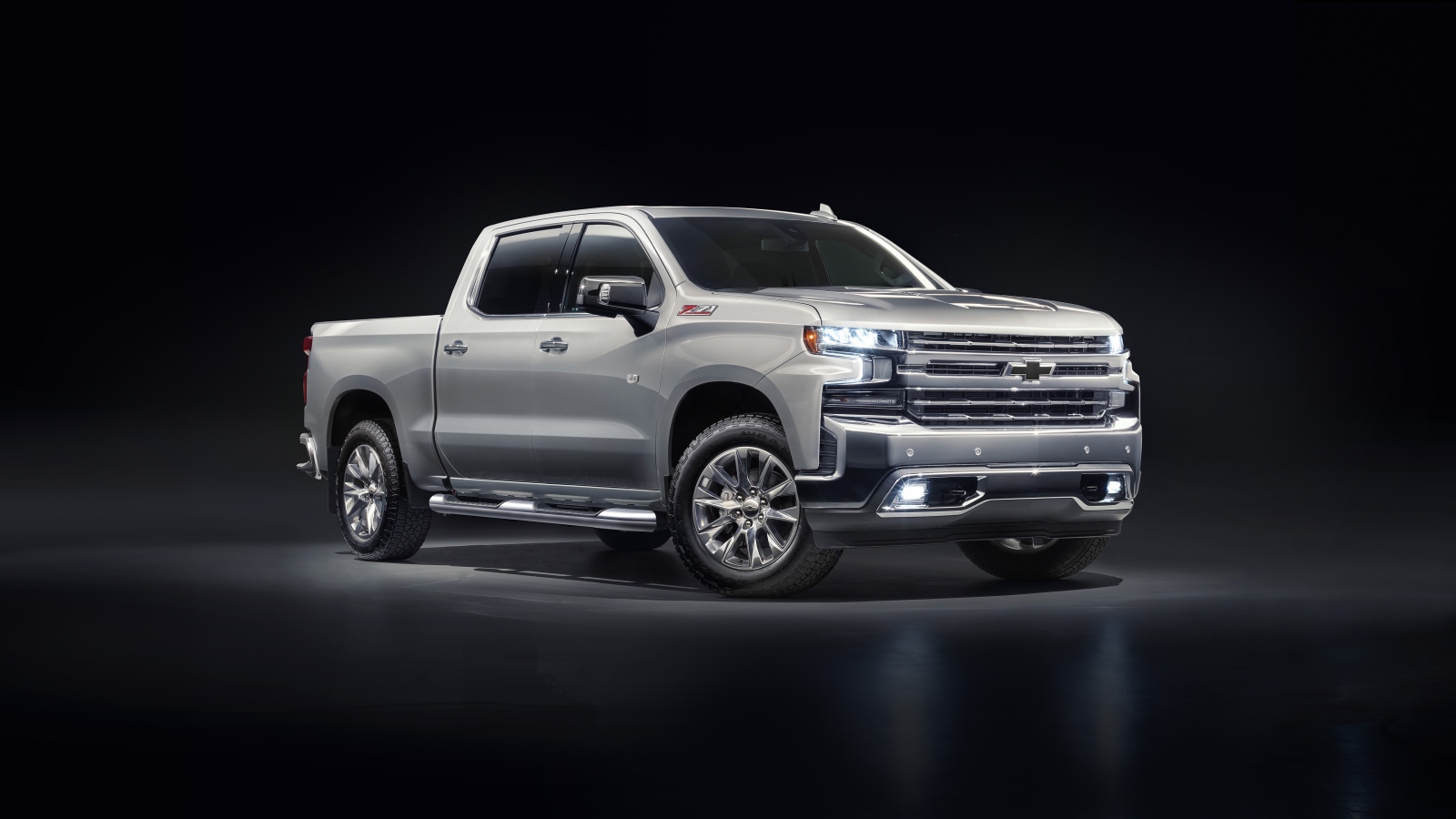 Серебристый автомобиль Chevrolet Silverado 1500 LTZ Z71 Premium Edition 2020 года на черном фоне