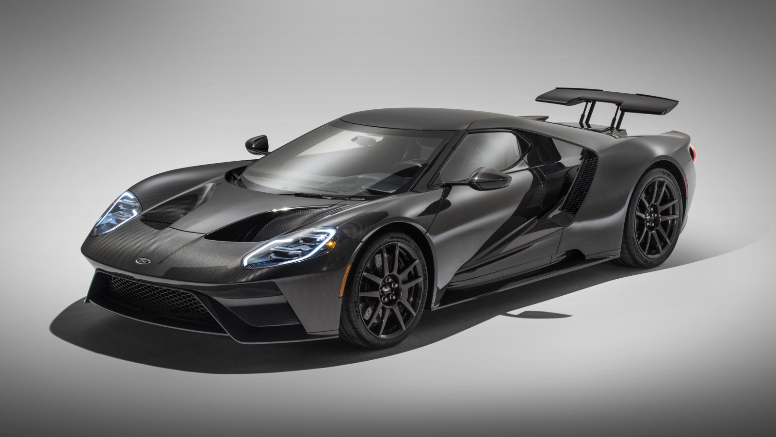 Серебристый спортивный Ford GT Liquid Carbon, 2020 года на сером фоне