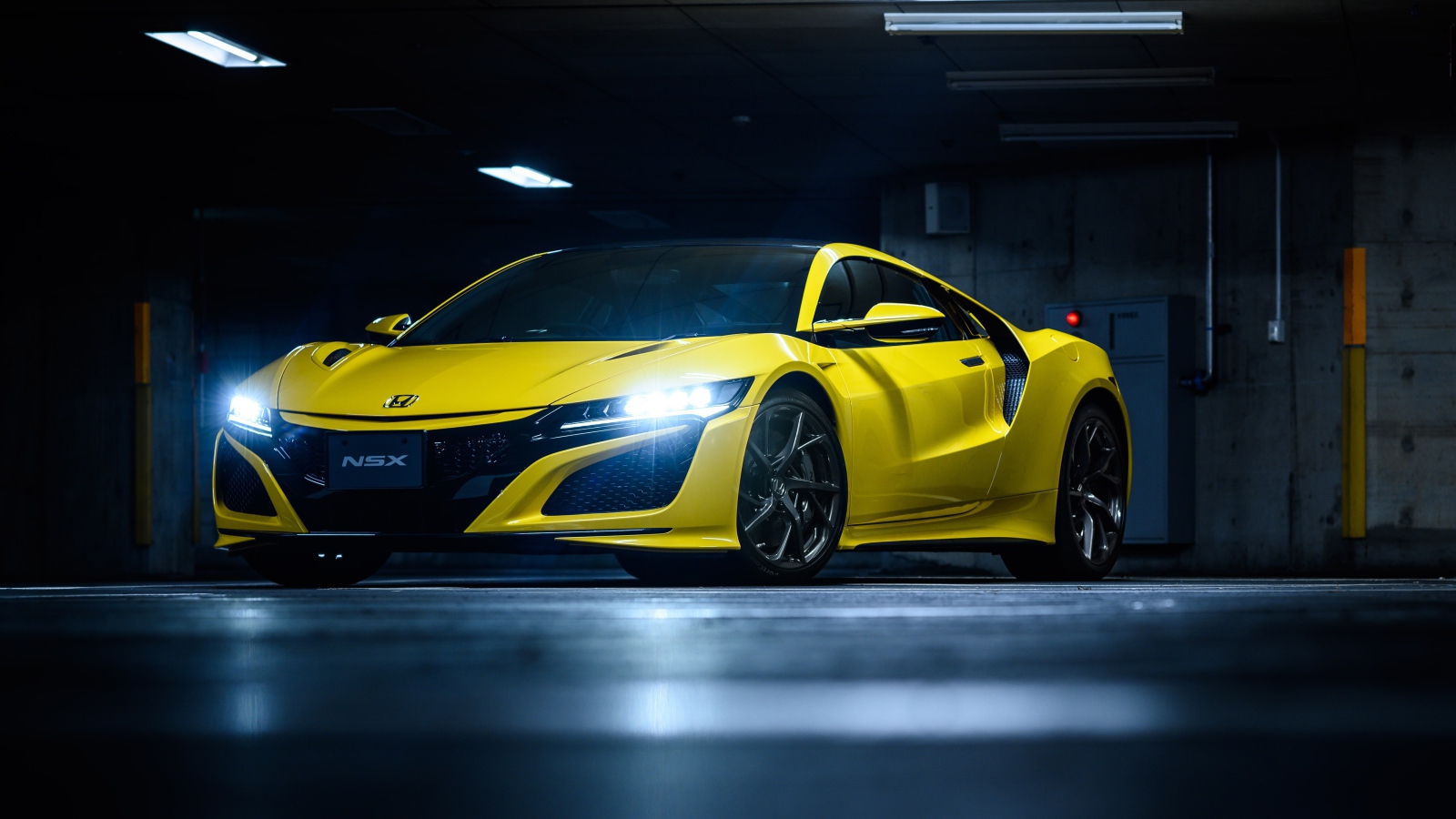 Желтый автомобиль Honda NSX с включенными фарами 