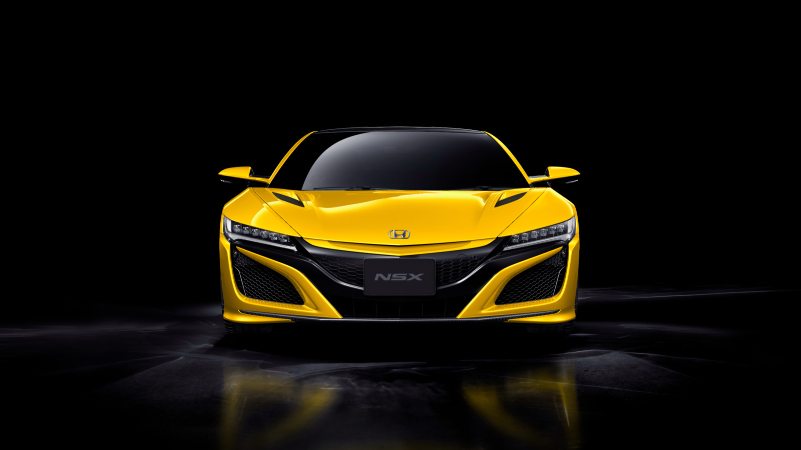 Желтый спортивный автомобиль Honda NSX на черном фоне
