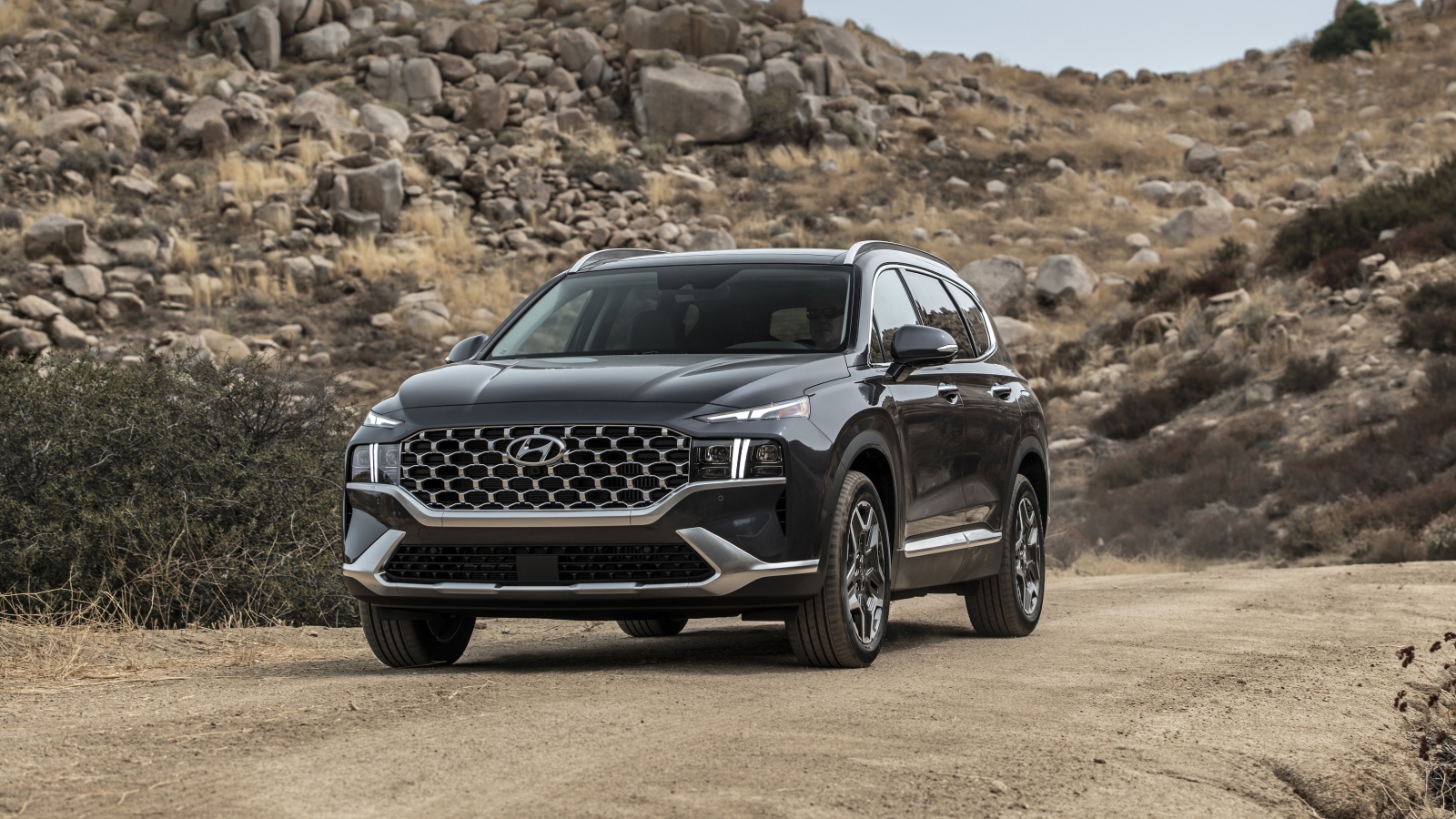 Черный автомобиль  Hyundai Santa Fe Hybrid, 2021 года у камней