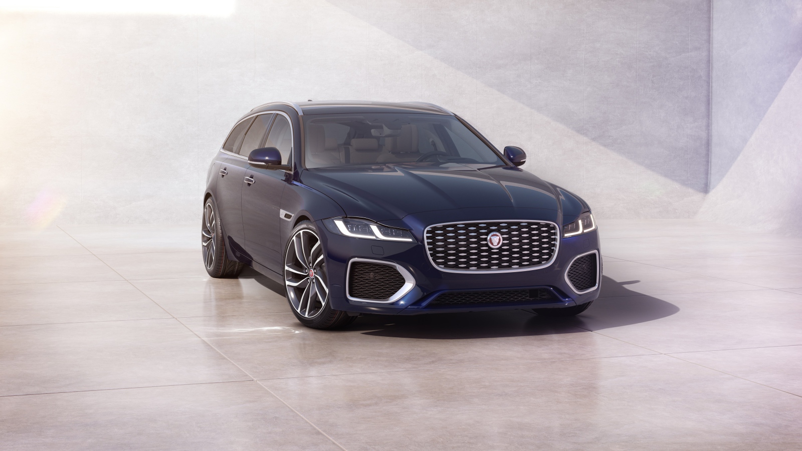 Синий автомобиль Jaguar XF Sportbrake 2020 года у стены 