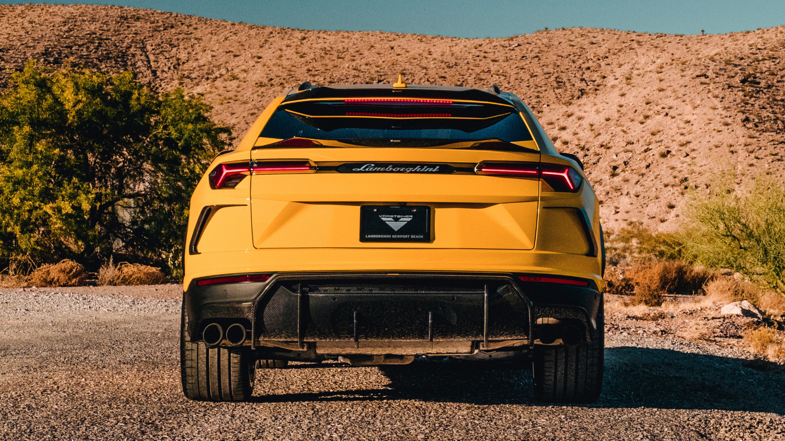 Желтый автомобиль Lamborghini Urus 2019 года вид сзади