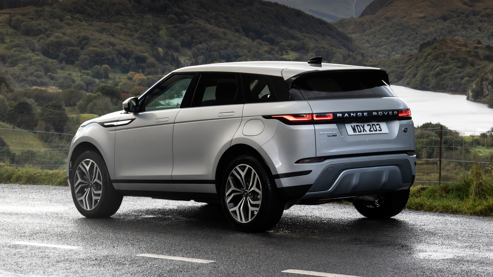 Серебристый автомобиль Range Rover Evoque P300e S 2020 года вид сзади