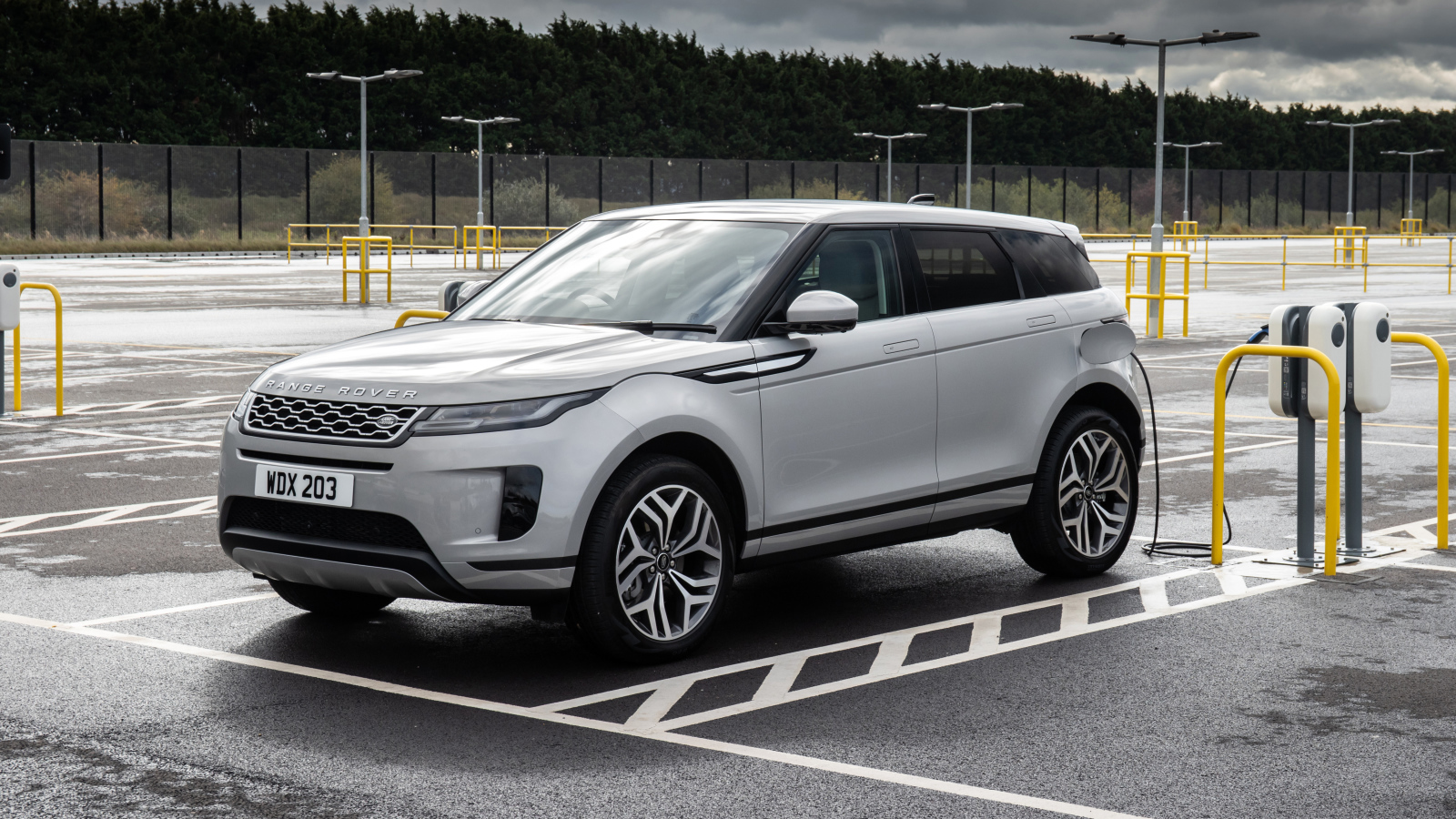 Серебристый автомобиль Range Rover Evoque P300e S 2020 года на заправке
