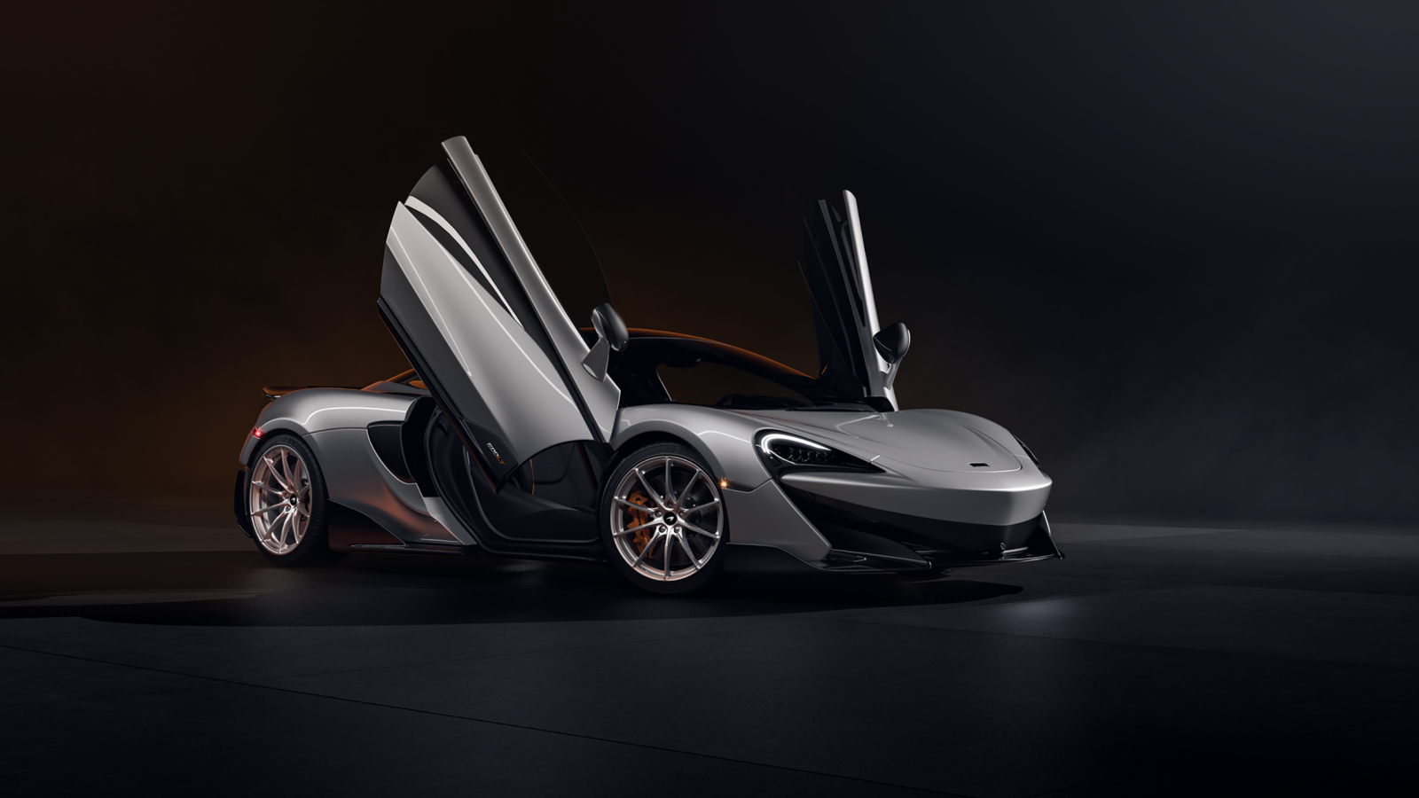 Серебристый спортивный автомобиль McLaren 600LT CGI с открытыми дверями