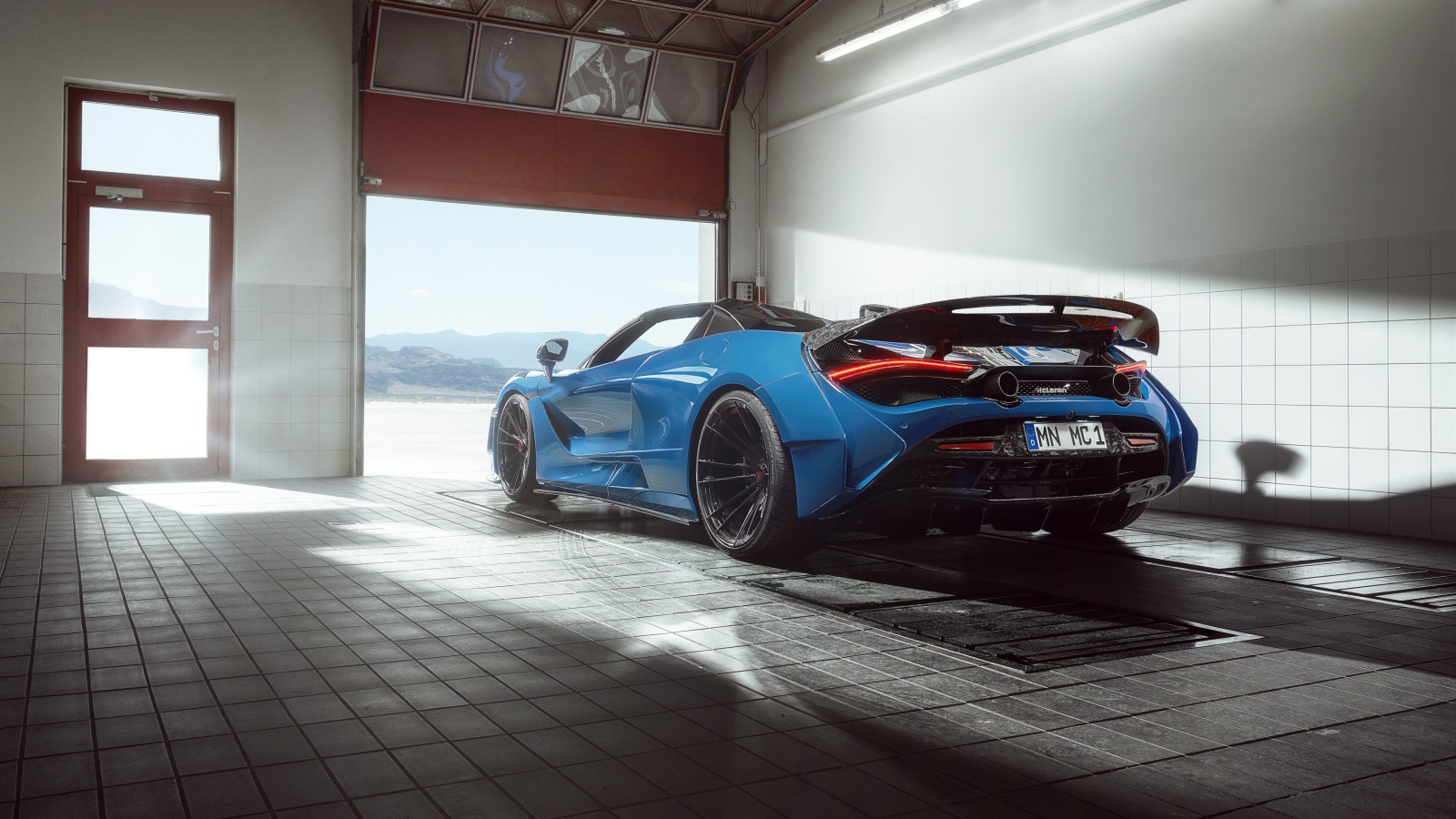 Спортивный автомобиль  McLaren 720S, 2020 года выезжает с гаража