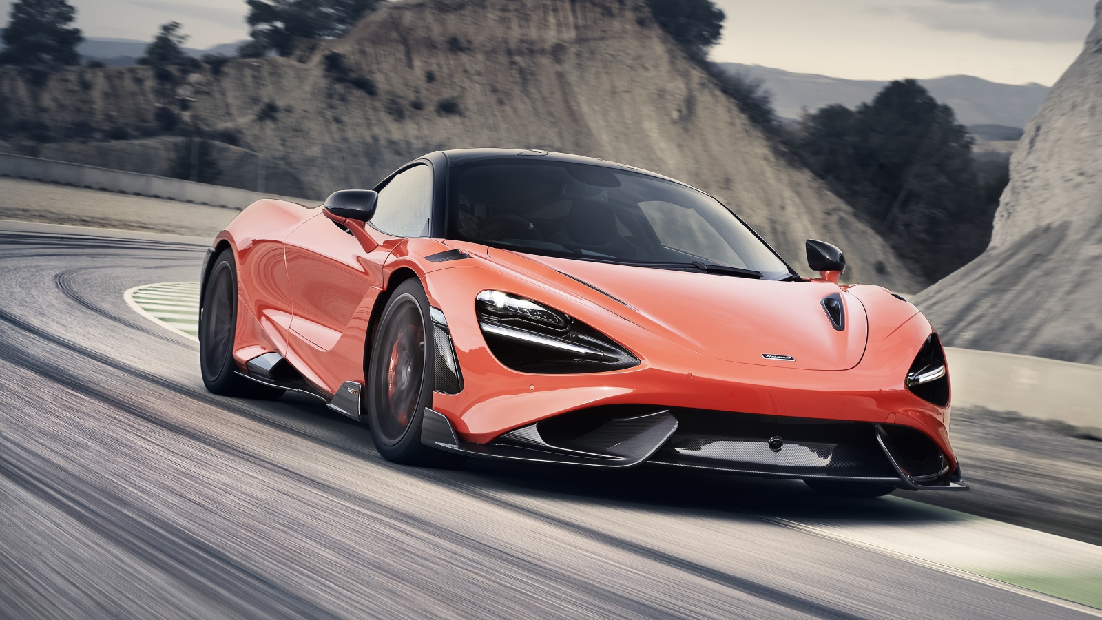 Красный автомобиль McLaren 765LT 2020 года на дороге в горах 