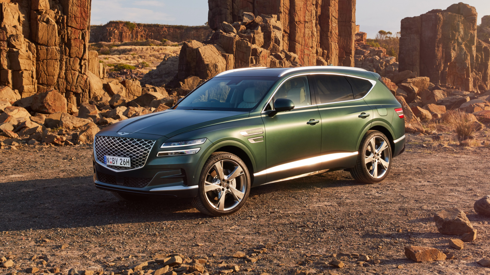 Зеленый автомобиль Genesis GV80 3.5T AWD 2020  года в горах