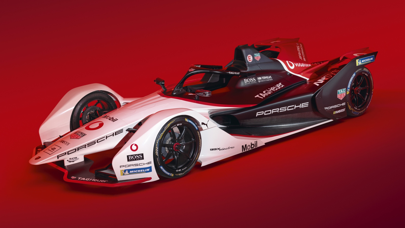 Гоночный автомобиль Porsche 99X Electric 2019 года на красном фоне