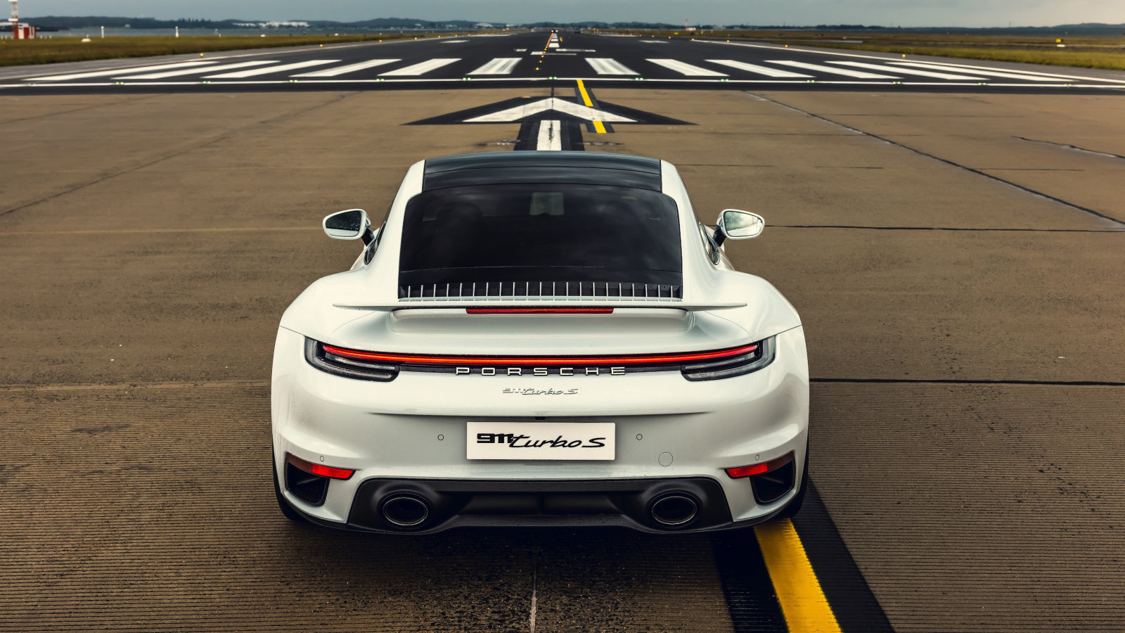 Белый автомобиль  Porsche 911 Turbo S 2020 года вид сзади