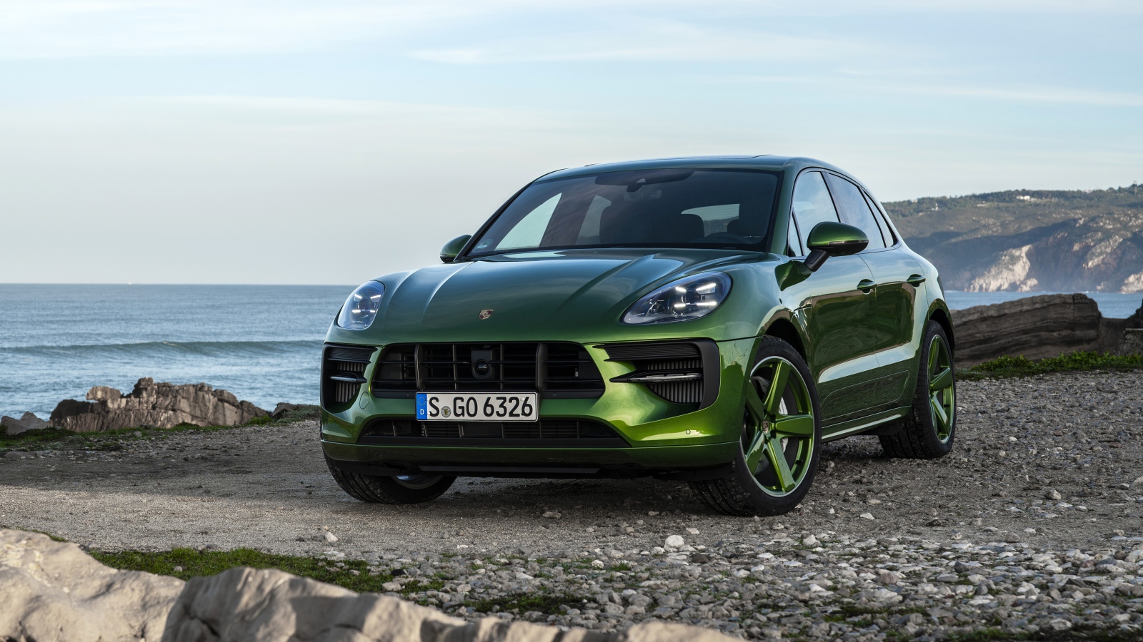 Зеленый автомобиль Porsche Macan GTS 2020 года на берегу моря