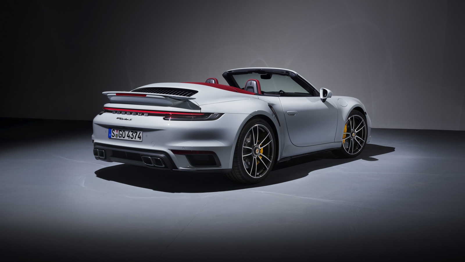 Белый автомобиль Porsche 911 Turbo S Cabriolet 2020 года вид сзади